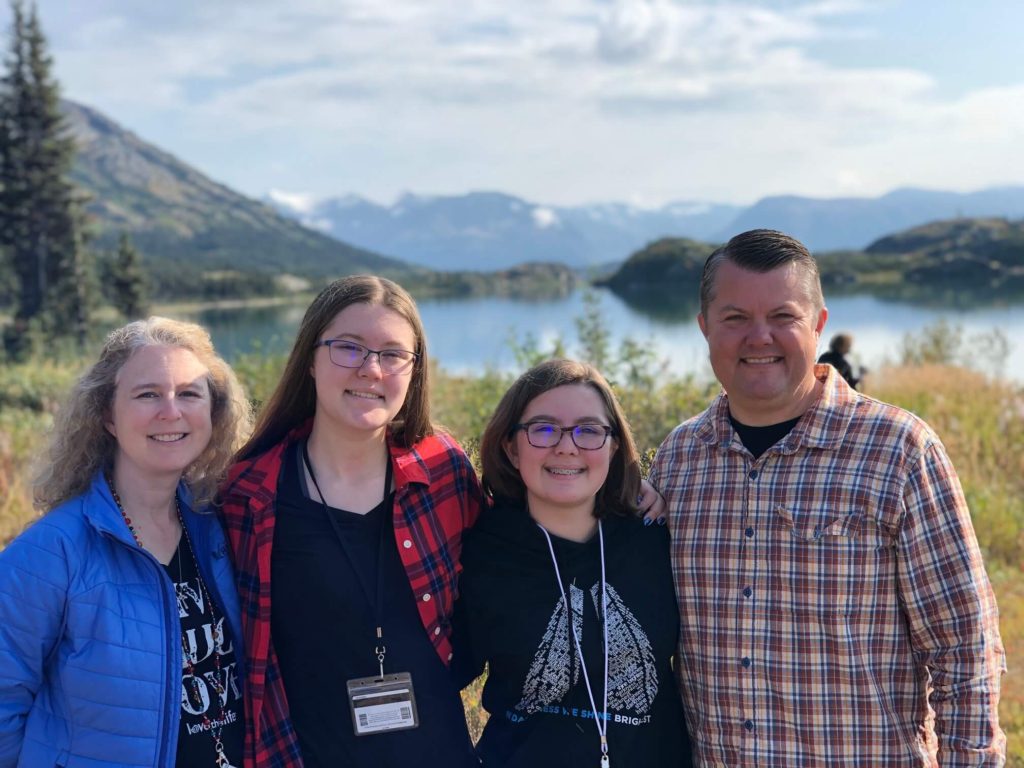 family photo - LaKrisha, Kiersten, Kaitlyn, David - in mountainous scenery by a lake