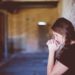 girl praying by a brick wall