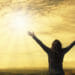 woman standing with arms outstretched in the sun